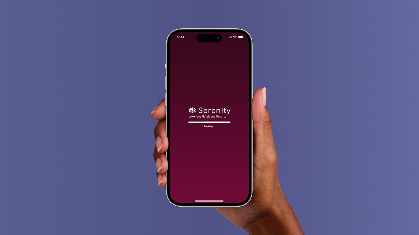 Hand holding iPhone showing Serenity Hotels loading screen